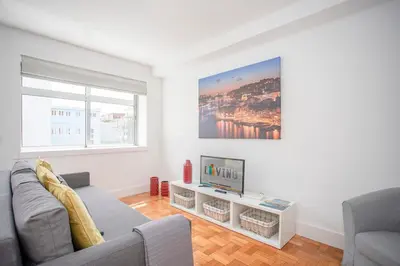 a living room with a couch and a tv at Liiiving in Porto - Sunny Santa Catarina in Porto