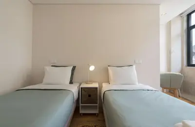 two beds sitting next to each other in a room at BmyGuest - São Vitor Balcony Apartment in Porto