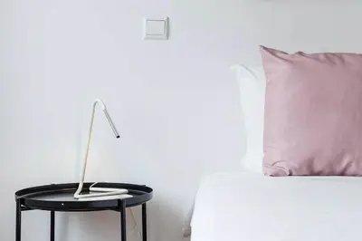 a bed with a table with a lamp and a pillow at Loulé 246 · 1 bedroom apartment · Parking in Porto