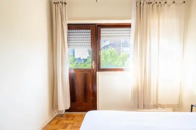 a bedroom with a bed and a window at Convenient 3-Bedroom Apartments next to Bom Sucesso in Porto