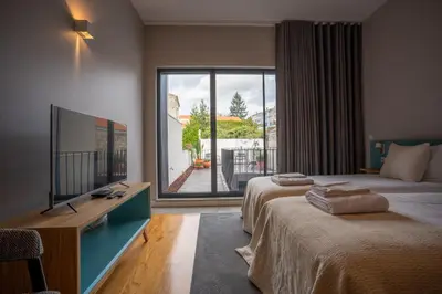 a hotel room with two beds and a large window at Oporto Trendy Formosa in Porto
