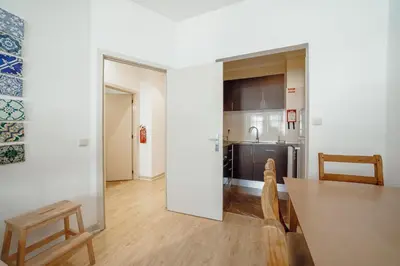 a kitchen and dining room with a table and chairs at Alegria Flat City Center with Elevator by Vacationy in Porto