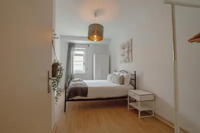 a bedroom with a bed in a white room at Alegria Flat City Center with Elevator by Vacationy in Porto