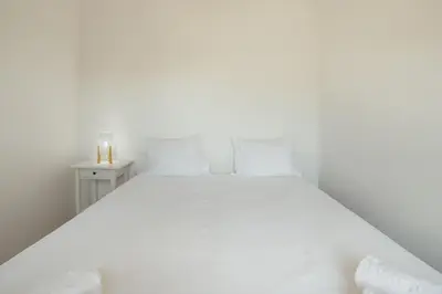 a bedroom with a white bed and a large window at Bright Boavista by Vacationy in Porto