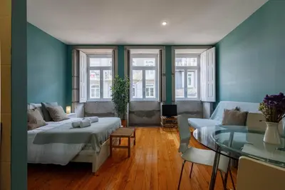 a bedroom with blue walls and a bed and a table at CLUBE Charming Apartments - São Bento in Porto