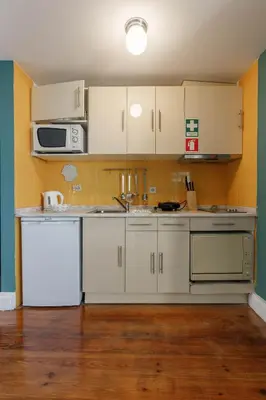 a kitchen with white cabinets and a sink and a microwave at CLUBE Charming Apartments - São Bento in Porto