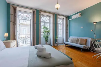 a large bedroom with a large bed with blue walls at CLUBE Charming Apartments - São Bento in Porto