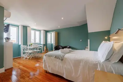a bedroom with a white bed and green walls at CLUBE Charming Apartments - São Bento in Porto