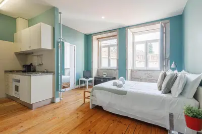 a bedroom with a white bed and blue walls at CLUBE Charming Apartments - São Bento in Porto