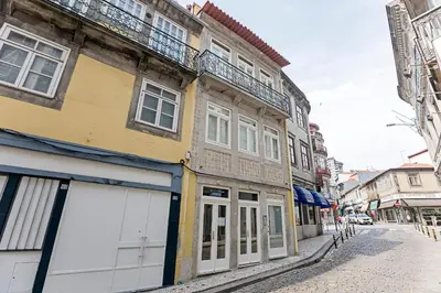 an old building with white doors on a street at Turquoise Central Flat w AC & Balcony by LovelyStay in Porto