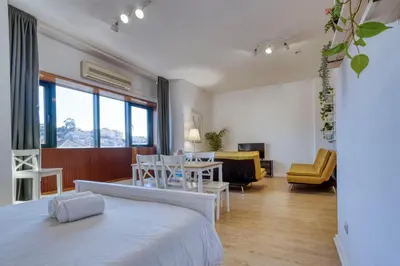 a bedroom with a bed and a living room at Travel and Live Faria Guimarães in Porto