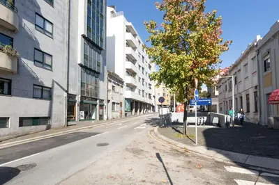 an empty street in a city with tall buildings at Travel and Live Faria Guimarães in Porto