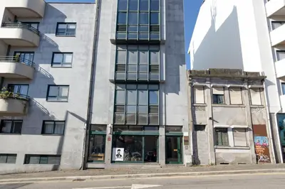a tall building on a city street at Travel and Live Faria Guimarães in Porto