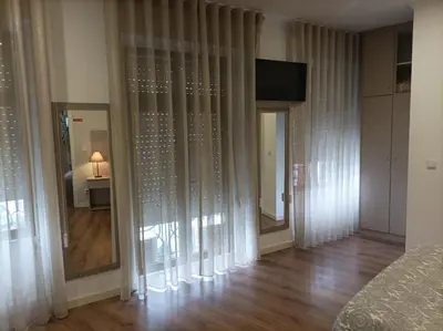 a room with curtains and a room with a television at HOSPEDARIA LONDRES in Porto