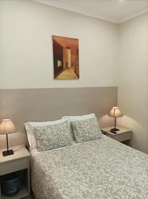 a bedroom with a bed with two lamps on tables at HOSPEDARIA LONDRES in Porto