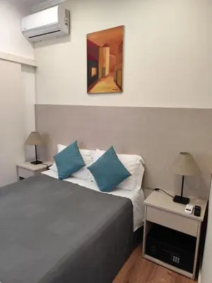 a bedroom with a bed and a painting on the wall at HOSPEDARIA LONDRES in Porto