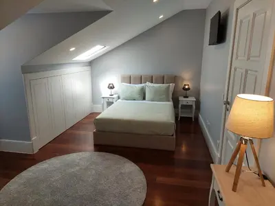 a bedroom with a bed and two tables and a lamp at Cool Suites in Porto