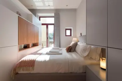 a bedroom with a large white bed and a window at Tripas-Coração, Almada Charming City Center in Porto