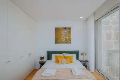 a white bedroom with a large bed with orange pillows at Chimney Luxury House with AC in Porto