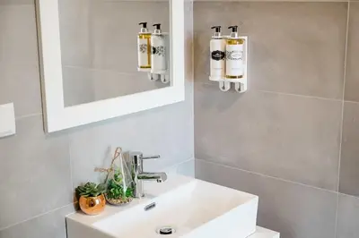 a bathroom with a white sink and a mirror at Chimney Luxury House with AC in Porto