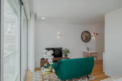 a living room with a green couch and a tv at Chimney Luxury House with AC in Porto