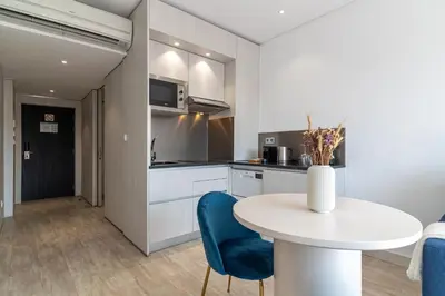 a kitchen with a white table and blue chairs at Smartr Porto Gaia & Spa in Vila Nova de Gaia
