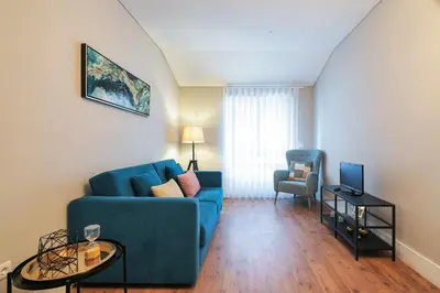a living room with a blue couch and a chair at Virtudes Flat in Porto