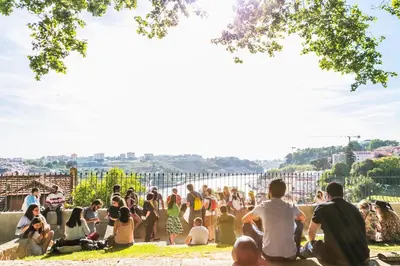 a crowd of people sitting on the grass in a park at Virtudes Flat in Porto