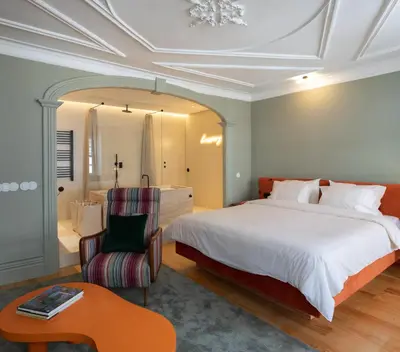 a bedroom with a large bed and a chair at Almadina Smart Luxury in Porto