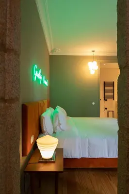 a bedroom with a bed with a neon sign on the wall at Almadina Smart Luxury in Porto
