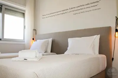 a bedroom with a bed with white sheets and a window at 115 OPorto Guest House in Porto