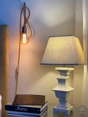 a lamp sitting on a table next to a stack of books at 115 OPorto Guest House in Porto