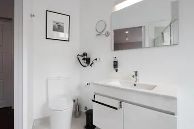 a white bathroom with a sink and a mirror at Utopian - Design Suites Porto - Free Minibar in Porto
