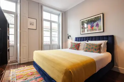 a bedroom with a large bed with a yellow blanket at Utopian - Design Suites Porto - Free Minibar in Porto