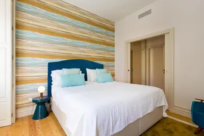a bedroom with a bed with a colorful accent wall at BOUTIQUE Rentals-Isabella Ribeira Apt great views in Porto