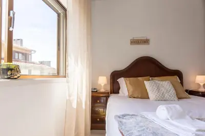 a bedroom with a bed and a large window at Metro Lapa House with sunny balcony and A/C in Porto