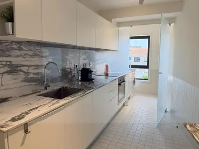 a kitchen with white cabinets and a sink at Atayde da Câmara - Porto in Porto