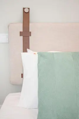 a bed with a cross on the head board at Liiiving in Porto - Sweet Sunlight Apartment in Porto