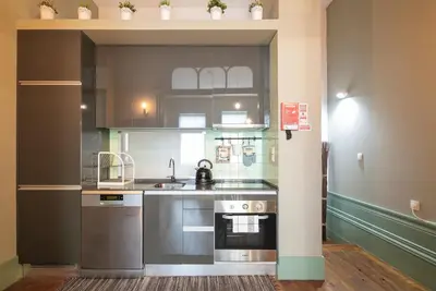 a kitchen with a sink and a stove at Oporto family apartment in Porto