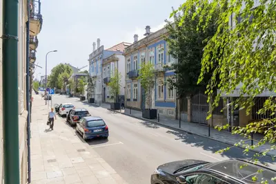 a street with cars parked on the side of the road at Oporto family apartment in Porto