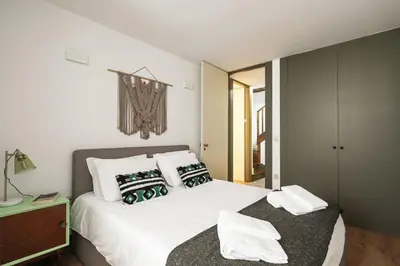 a bedroom with a white bed with two pillows at Oporto family apartment in Porto