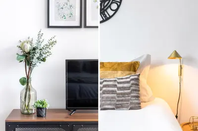 a bedroom with a bed and a tv and a vase of flowers at S. Lázaro Studio in Porto