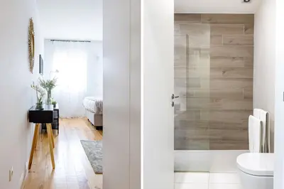 a bathroom with white walls and a glass shower door at S. Lázaro Studio in Porto