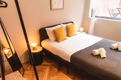 a bedroom with a bed with yellow pillows and a window at São Lázaro's Garden - Apartment With Terrace in Porto