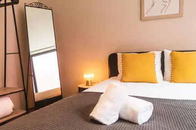 a bedroom with two beds with yellow pillows and a mirror at São Lázaro's Garden - Apartment With Terrace in Porto