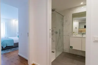 a bathroom with a glass shower and a bed at Stunning Apartment w/ Free Parking by LovelyStay in Porto