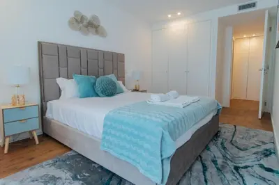 a bedroom with a large bed with blue pillows at Stunning Apartment w/ Free Parking by LovelyStay in Porto