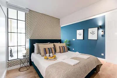 a room with three windows and a view of a city at Urban House by LovelyStay in Porto