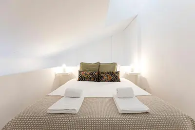 a white bedroom with a large bed with white walls at Urban House by LovelyStay in Porto