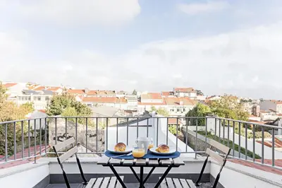 a table with two plates of food on a balcony at Urban House by LovelyStay in Porto